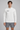 AI-generated model simulation of White MT0064, front view with black Olvaxe on wearer-right chest; shorts not included