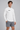 AI-generated model simulation of White MT0064, three-quarter front view with black Olvaxe on wearer-right chest; shorts not included